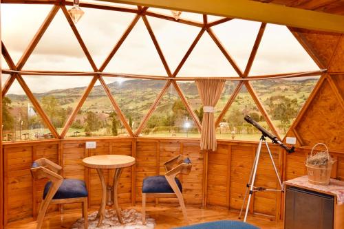 a room with a large window with chairs and a table at Villa Rebequita in Villapinzón
