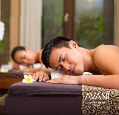 two men laying on a bed with their eyes closed at Goldcoast Palm Tree Sepang Luxury Resort in Sungai Pelik