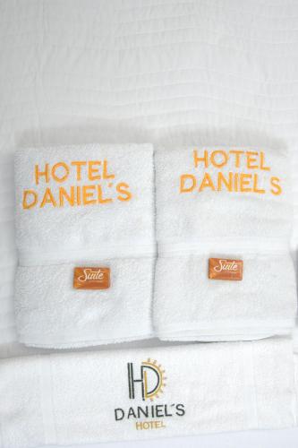 a pile of towels on a bed with their logos at Hotel Daniels in Fonseca