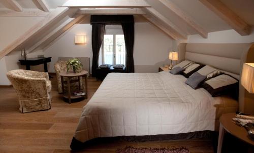 a bedroom with a large white bed and a piano at Villa Hvar Royale - 5 Bedroom Central Villa - Indoor Pool - Beautiful Heritage Villa in Hvar