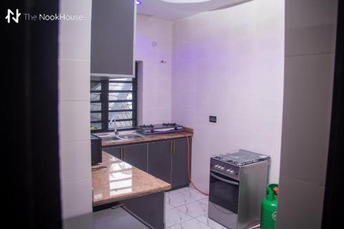 a small kitchen with a sink and a stove at The NookHouse in Calabar