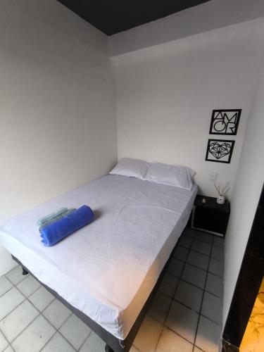 a bed in a room with a blue container on it at Mini Suite Comforto in Garanhuns