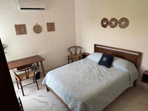 a bedroom with a bed and a table and a desk at 3E- Condominio exclusivo con alberca in Manzanillo