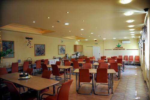 OÁZIS Hotel*** في نايغكانيشا: غرفة طعام مليئة بالطاولات والكراسي
