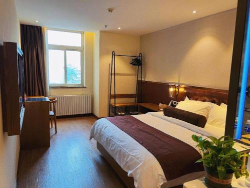 a hotel room with a large bed and a window at James Joyce Coffetel Shijiazhuang the Mixc Jinyuan Tower Airport Bus in Shijiazhuang