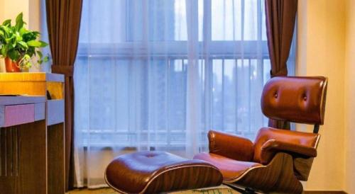 a brown chair sitting in front of a window at James Joyce Coffetel· Xianyang Renmin Road Central Square Store in Xianyang