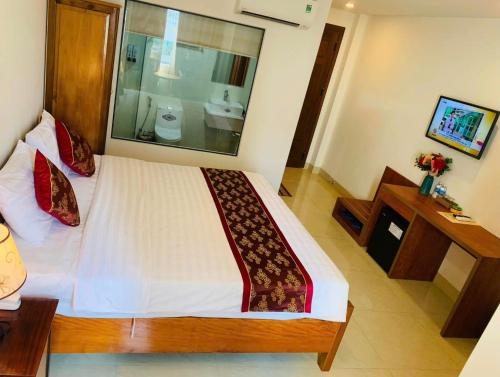a bedroom with a large bed and a bathroom at Happy Beach Hotel in Nha Trang