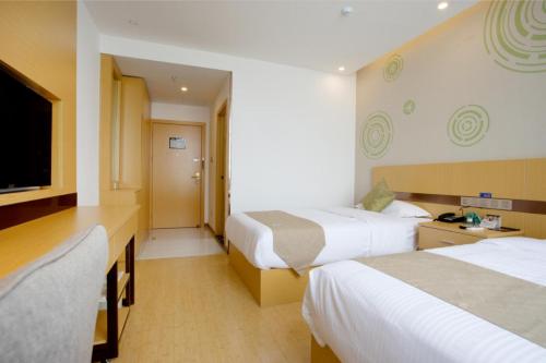 a hotel room with two beds and a flat screen tv at GreenTree Inn Linhai Jiangnan Avenue Express in Linhai
