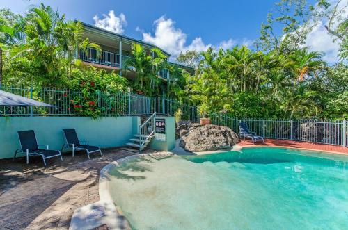 a swimming pool in front of a house with a resort at Heliconia Grove - 1 bedroom - on Hamilton Island by HIHA in Hamilton Island