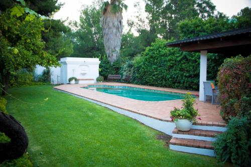 una piscina in un cortile con una casa di Lemon & Lime Guesthouse a Bloemfontein