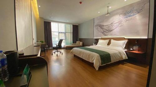 a bedroom with a bed and a desk with a chair at GreenTree Inn Express Datong High-Speed Railway Station Wanda Plaza Fangte in Datong
