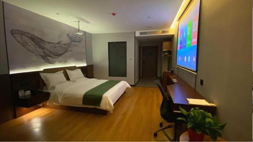 a bedroom with a bed and a desk and a television at GreenTree Inn Express Datong High-Speed Railway Station Wanda Plaza Fangte in Datong