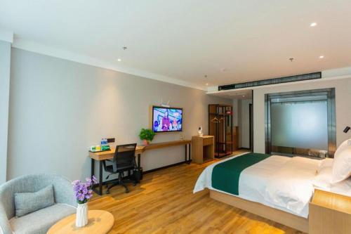 a bedroom with a bed and a desk and a tv at GreenTree Inn Express Datong High-Speed Railway Station Wanda Plaza Fangte in Datong