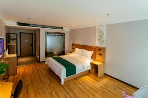 a bedroom with a large bed and a television at GreenTree Inn Express Datong High-Speed Railway Station Wanda Plaza Fangte in Datong