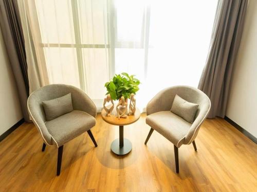 two chairs and a table in front of a window at GreenTree Inn Express Datong High-Speed Railway Station Wanda Plaza Fangte in Datong
