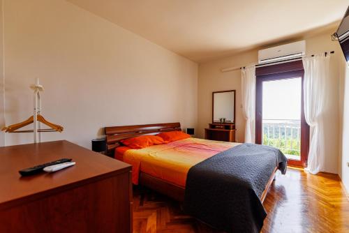 Un dormitorio con una cama y un escritorio y una ventana. en Venami Holiday Home, en Jadranovo