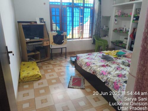a bedroom with a bed and a desk and a television at Arvind maurya home stye in Naimishāranya