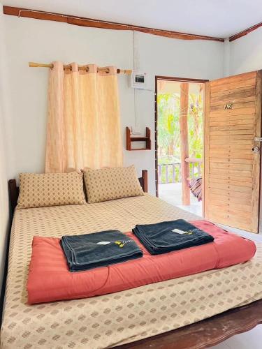a bedroom with a bed with two towels on it at สบายคันทรีรีสอร์ท ปากเมงSa-buy country resort Pak Meng in Sikao