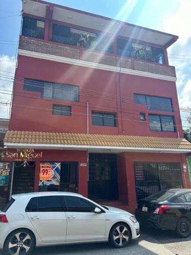 a white car parked in front of a red building at Beatiful aparment in the magical town of Orizaba 3 in Orizaba