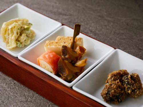 a tray with three white plates with different types of food at KAMENOI HOTEL Fukui in Fukui