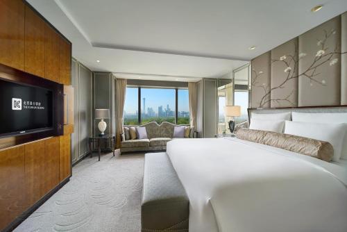 a hotel room with a large bed and a television at The Kunlun Beijing Jin Jiang Radisson in Beijing