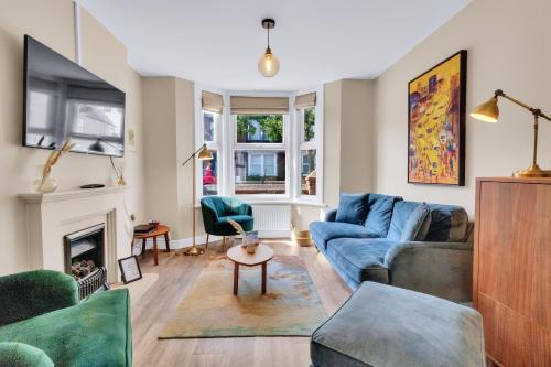 a living room with a blue couch and a fireplace at Oyster Stay House By My Getaways in Whitstable