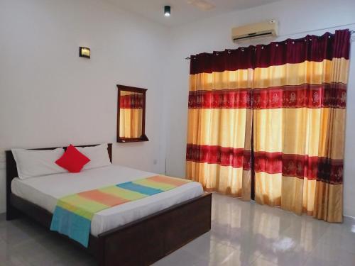 a bedroom with a bed and a colorful curtain at Ancient Village in Polonnaruwa
