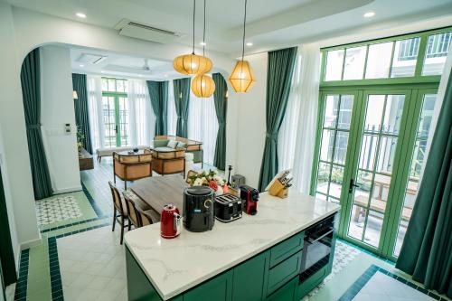 a kitchen with green cabinets and a table in a room at Biệt thự sân vườn sang trọng Hayha Villa - Tropical Garden Khem Beach in Phu Quoc