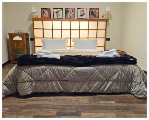 a bedroom with a large bed with two towels on it at Villa Marisa in Pavia