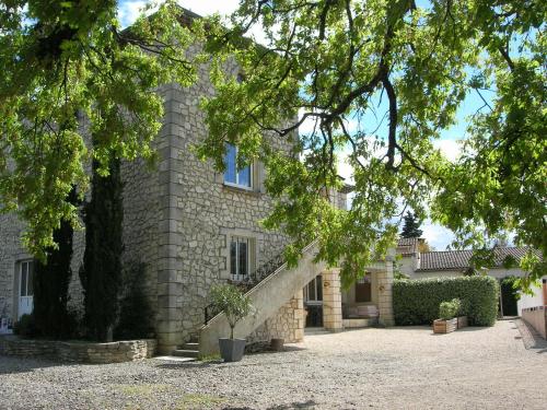 a stone house with a staircase in front of it at Gîtes Le Mas du Vieux Chêne in Salavas