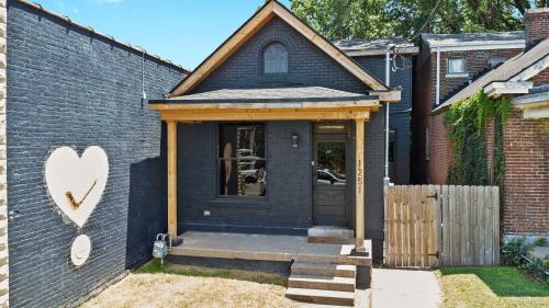 Casa azul con puerta de madera y valla en Unique Black Home in the Heart of Shelby Park, en Louisville