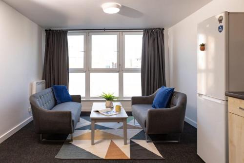 a living room with two chairs and a table at Albert Court in Liverpool in Liverpool