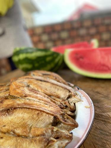 a plate of fish on a table with watermelon at Mountain View in Kochkor