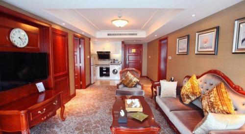 a living room with a couch and a tv at Xiamen Jingmin Central Hotel in Xiamen