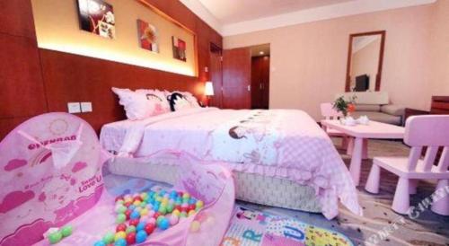 a bedroom with a pink bed with balls in it at Xiamen Jingmin Central Hotel in Xiamen