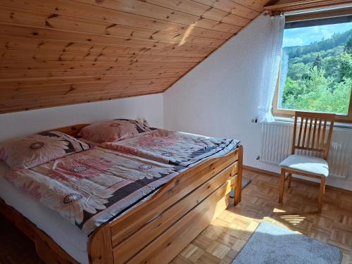 a bedroom with a bed with a wooden ceiling and a window at Krez Ferienhaus in Plein