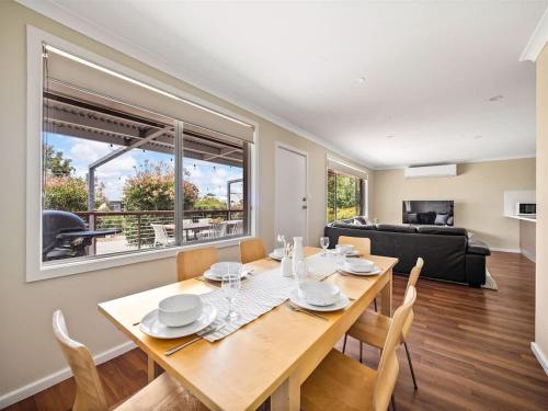 a dining room with a table and chairs and a couch at Eagle Bay Beach House - 300m to the beach! in Dunsborough
