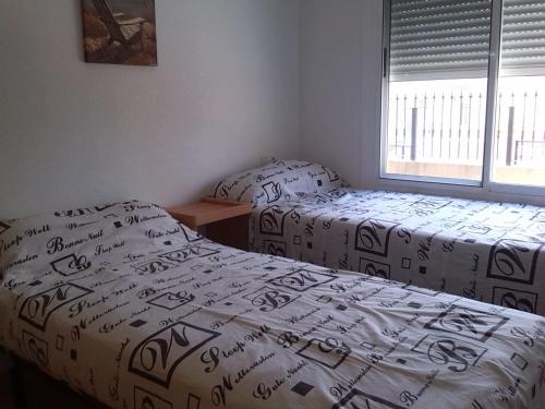 a bedroom with two beds and a window at Casa Panorama in Mazarrón