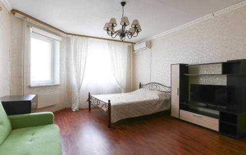 sypialnia z łóżkiem i telewizorem z płaskim ekranem w obiekcie DearHome Maykla Lunnа w mieście Bałaszycha