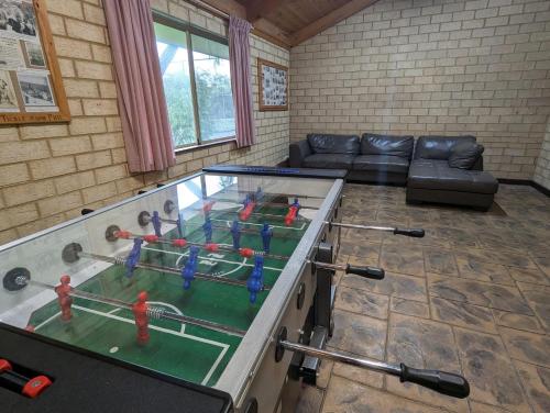a ping pong table in a living room with a couch at Siesta Park Holiday Resort ABSOLUTE BEACHFRONT RESORT in Busselton