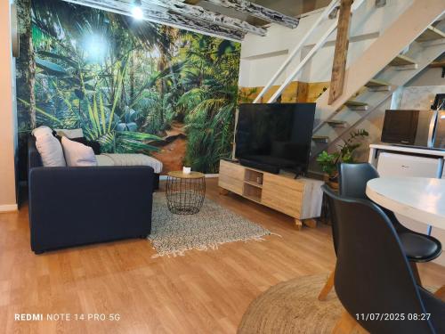 a living room with a tv and a large mural at Damaniel * Ze Détente * Jacuzzi* in Le Tampon