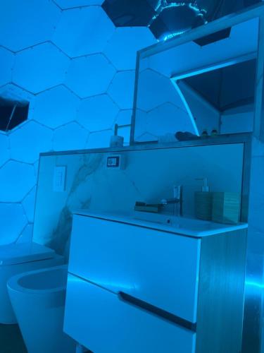 a blue bathroom with a sink and a toilet at Palmaria Sky Bubbles Room in Ponza