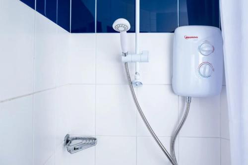 Una ducha en un baño de azulejos blancos con grifo. en Albert Court in Liverpool, en Liverpool