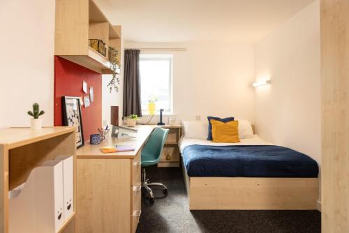 Habitación pequeña con cama, escritorio y lavabo. en Albert Court in Liverpool, en Liverpool