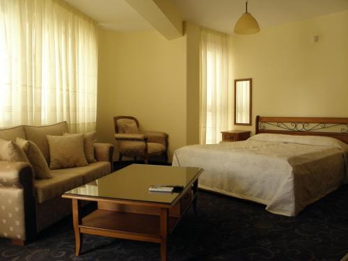 a hotel room with a bed and a couch at Anteya Serdika Apartments in Sozopol