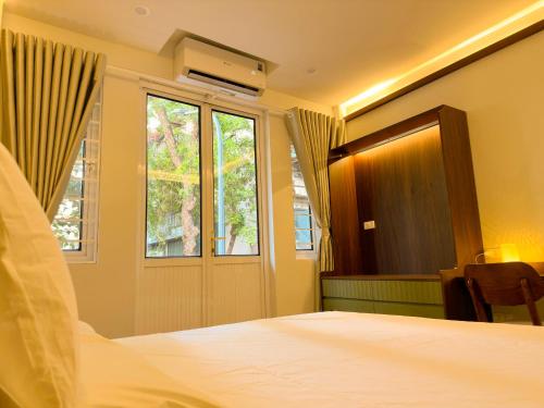 a bedroom with a bed and a window at Bamboura Home in Hanoi