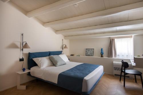 a bedroom with a king sized bed and a desk at Palazzo Botta Suites in Cefalù