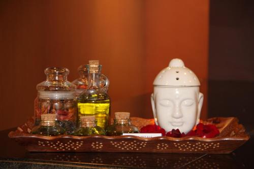 a tray with bottles of oils and a vase at Spice Grove in Thekkady