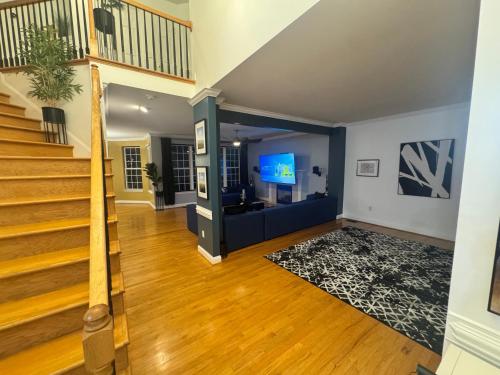 a living room with a staircase and a tv at Pprevalon in Gastonia