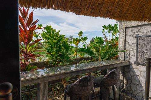 a view from the balcony of a resort with chairs at Authentic beachfront Villa Owl in Krambitan